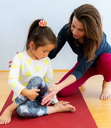 Michelle Wing teaching an IYK® Yoga Class with a young girl