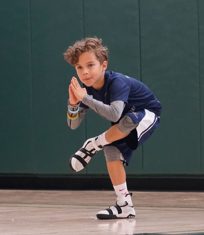 A boy doing Yoga at a school gym.