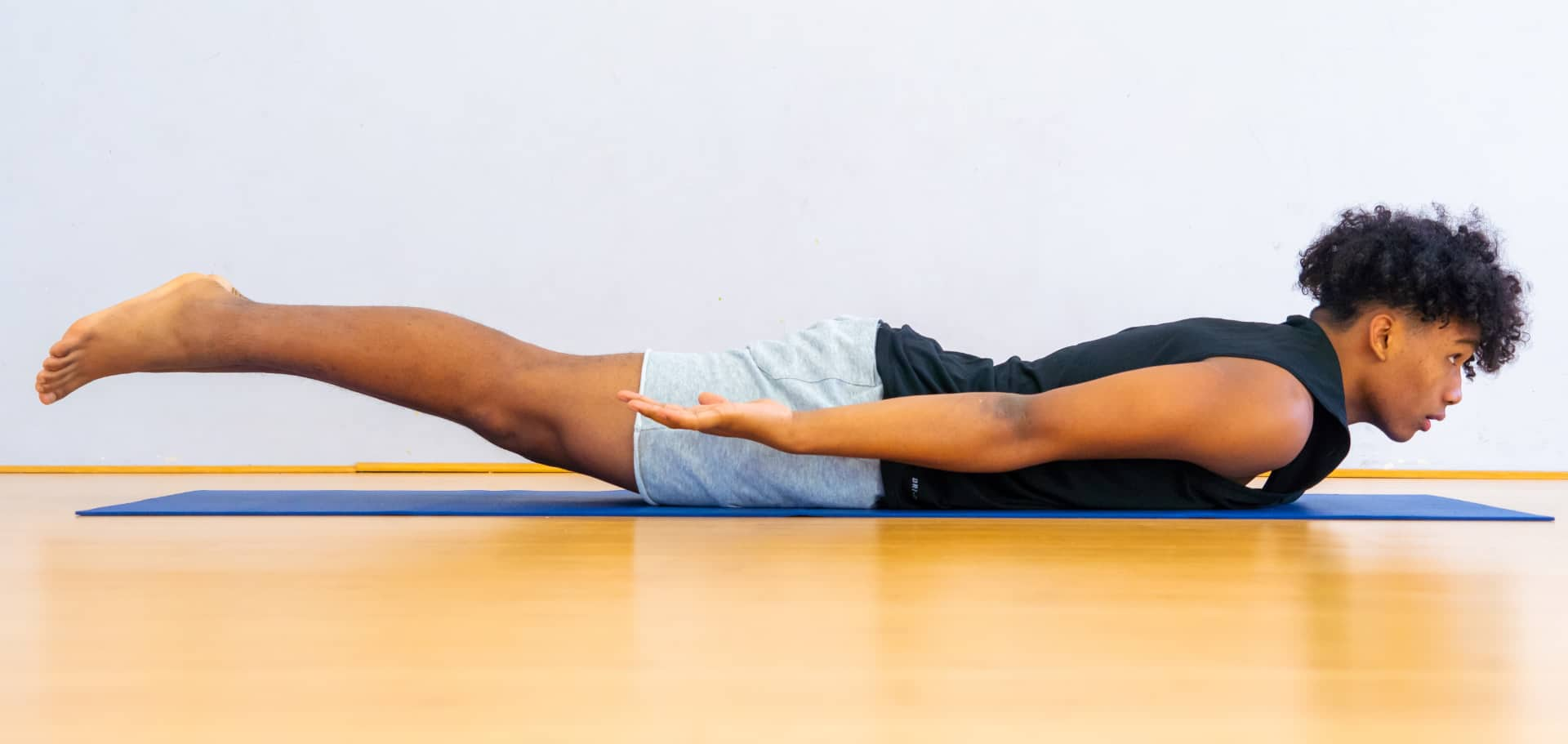 A teenager in superhero yoga pose.