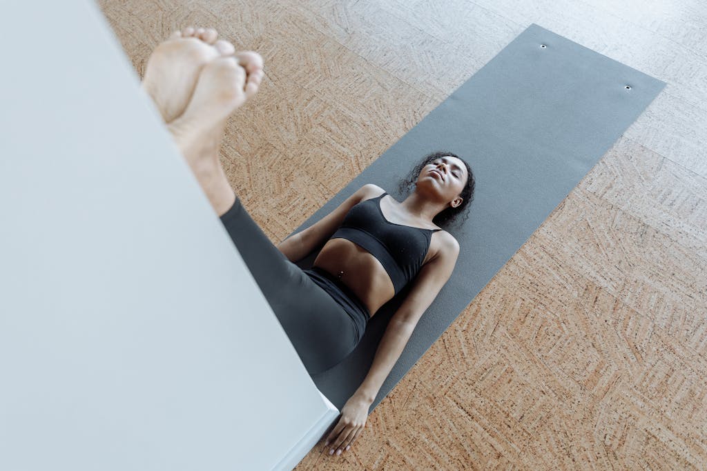 A black woman in legs up the wall yoga pose