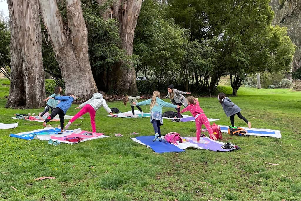 A group of kids doing yoga outdoors in the Presidio