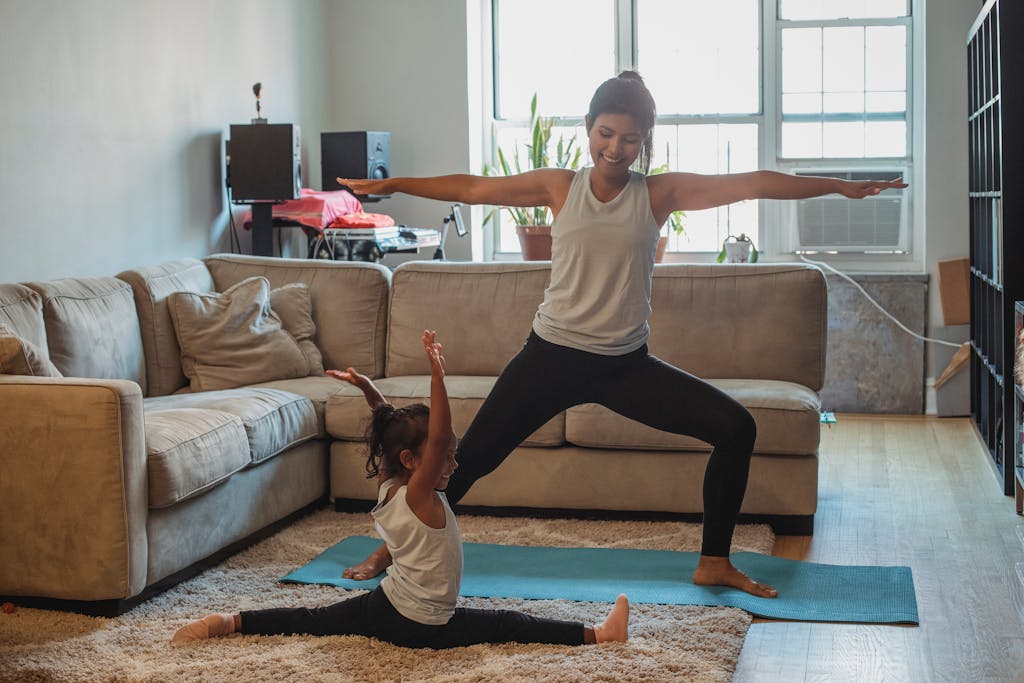 A mom in warrior pose and a child in the splits