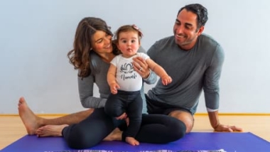 A mom, dad and baby doing yoga together at IYK® Baby + Toddler